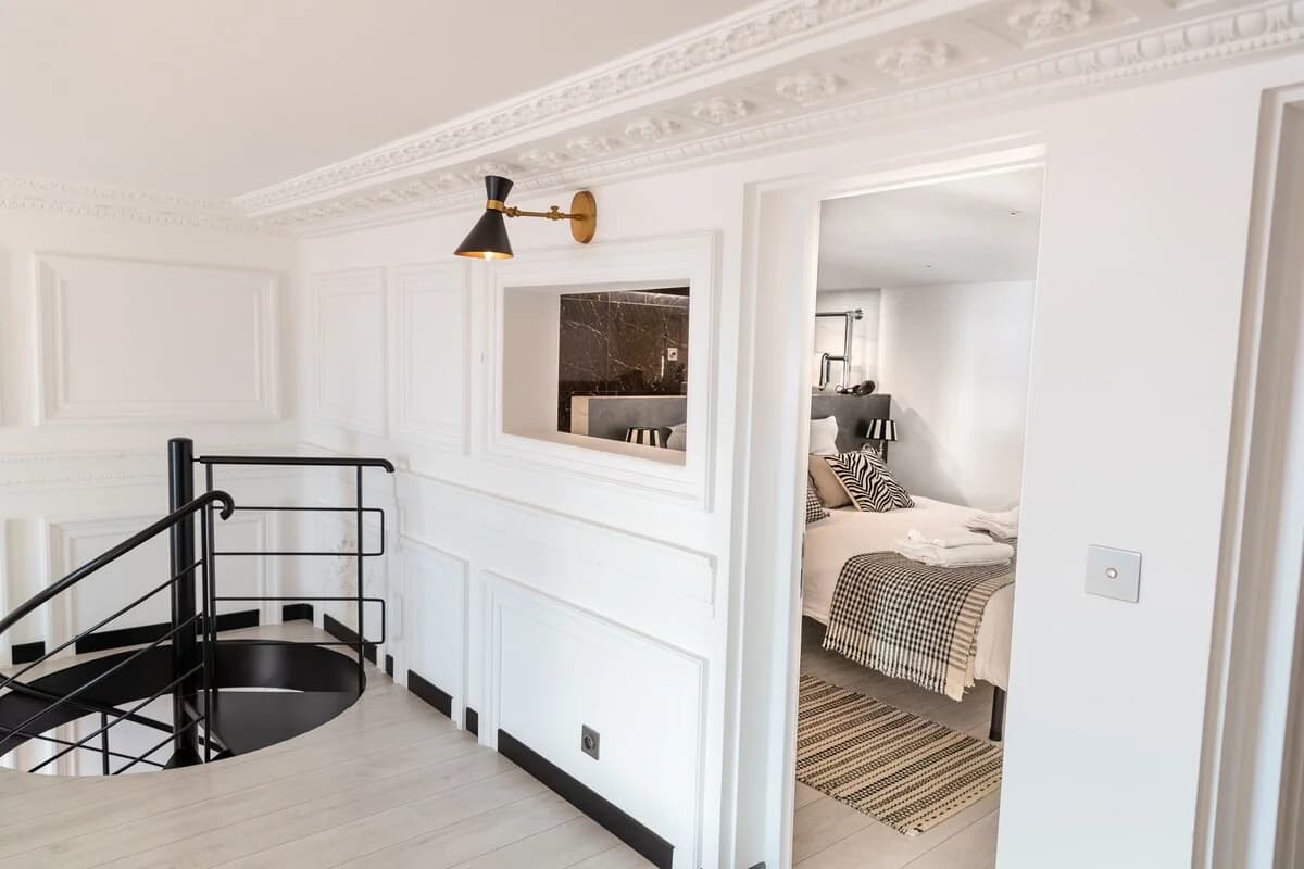 Mezzanine landing with ornate cornice peering into a bedroom suite