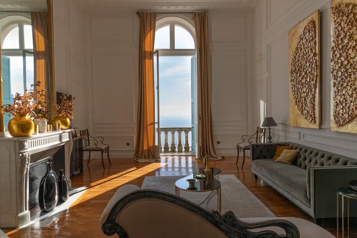 Grand salon with sea view through arched French doors and gilt artwork