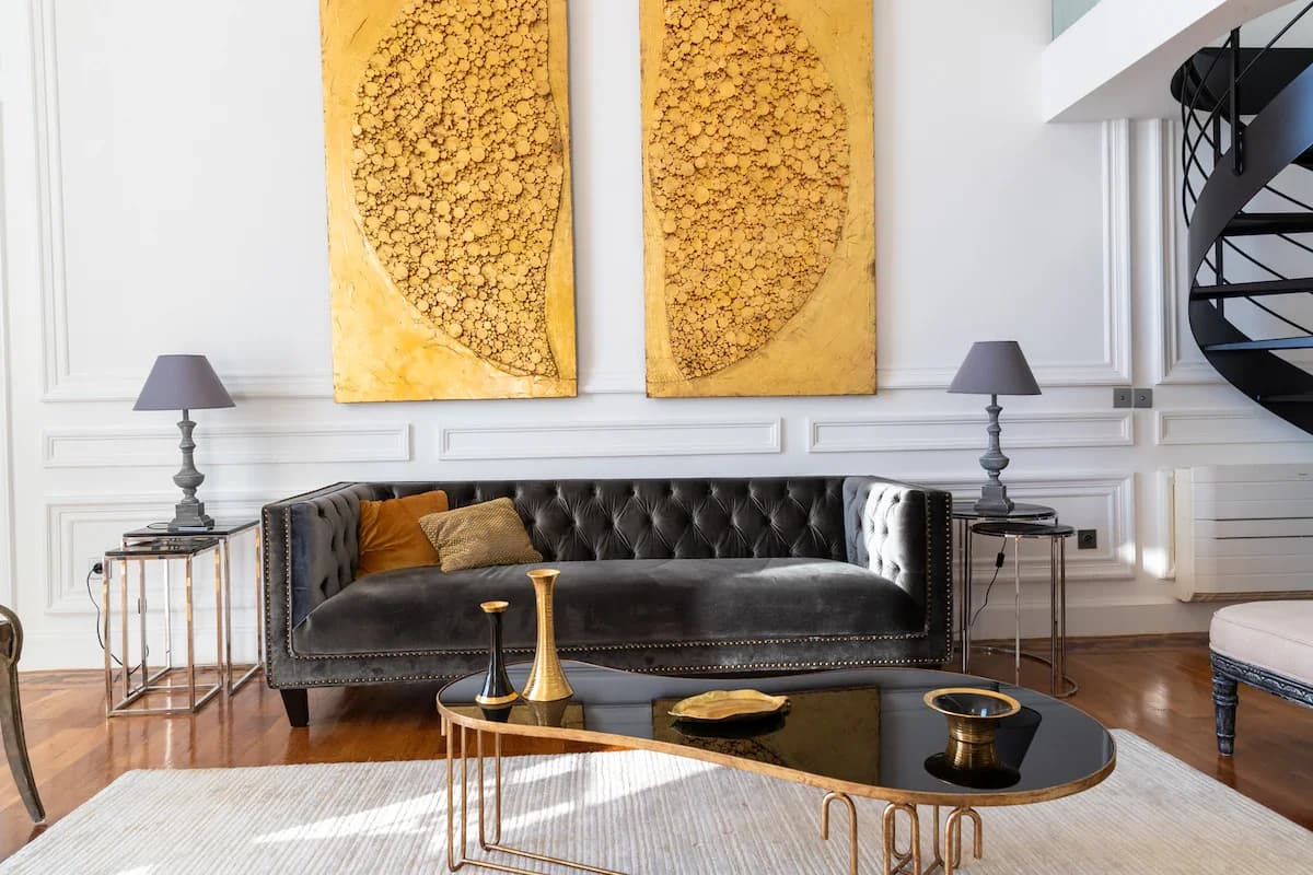 Symmetrical sitting vignette with chesterfield, twin lamps and gold panels