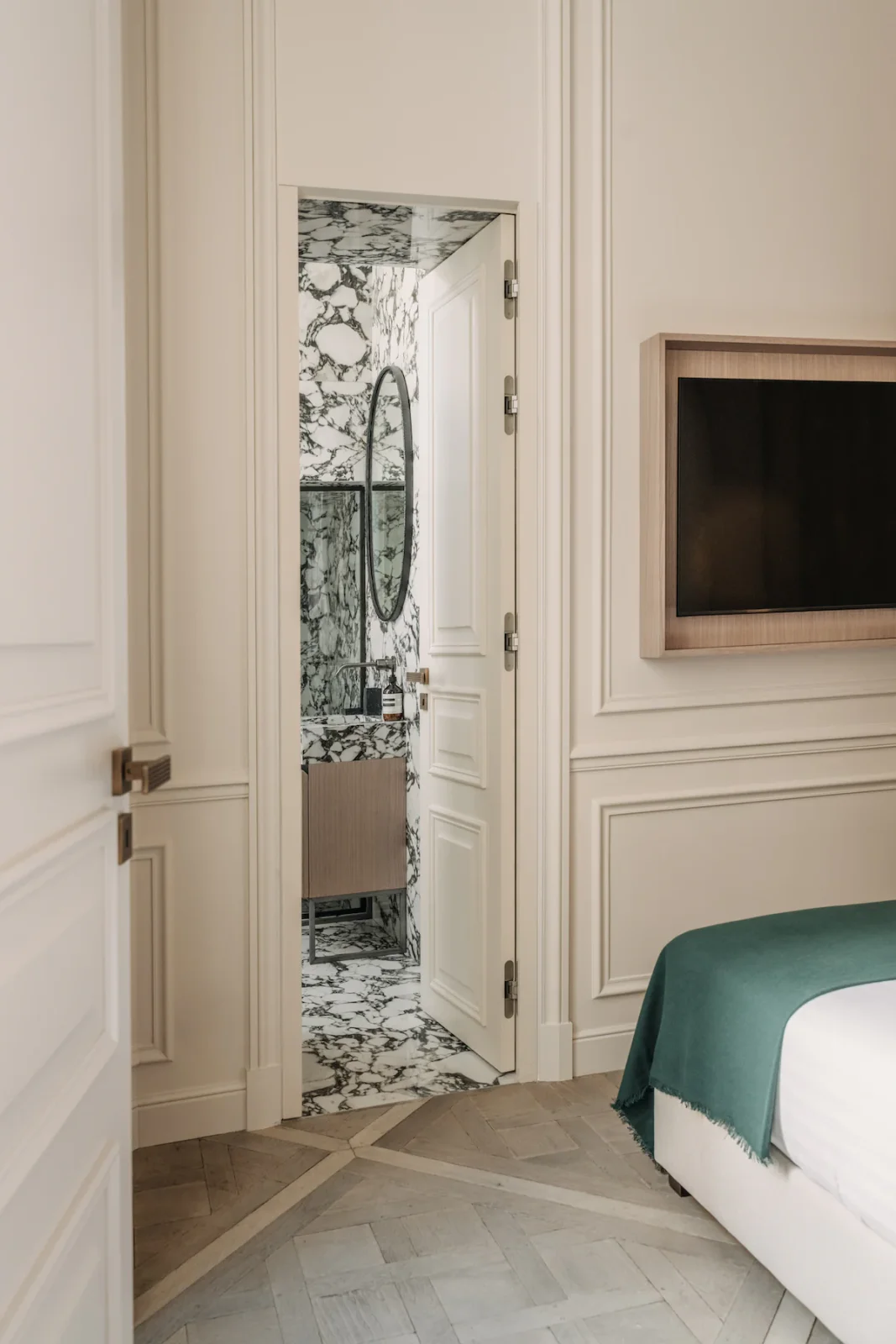 Bedroom doorway revealing the marble-clad ensuite beyond