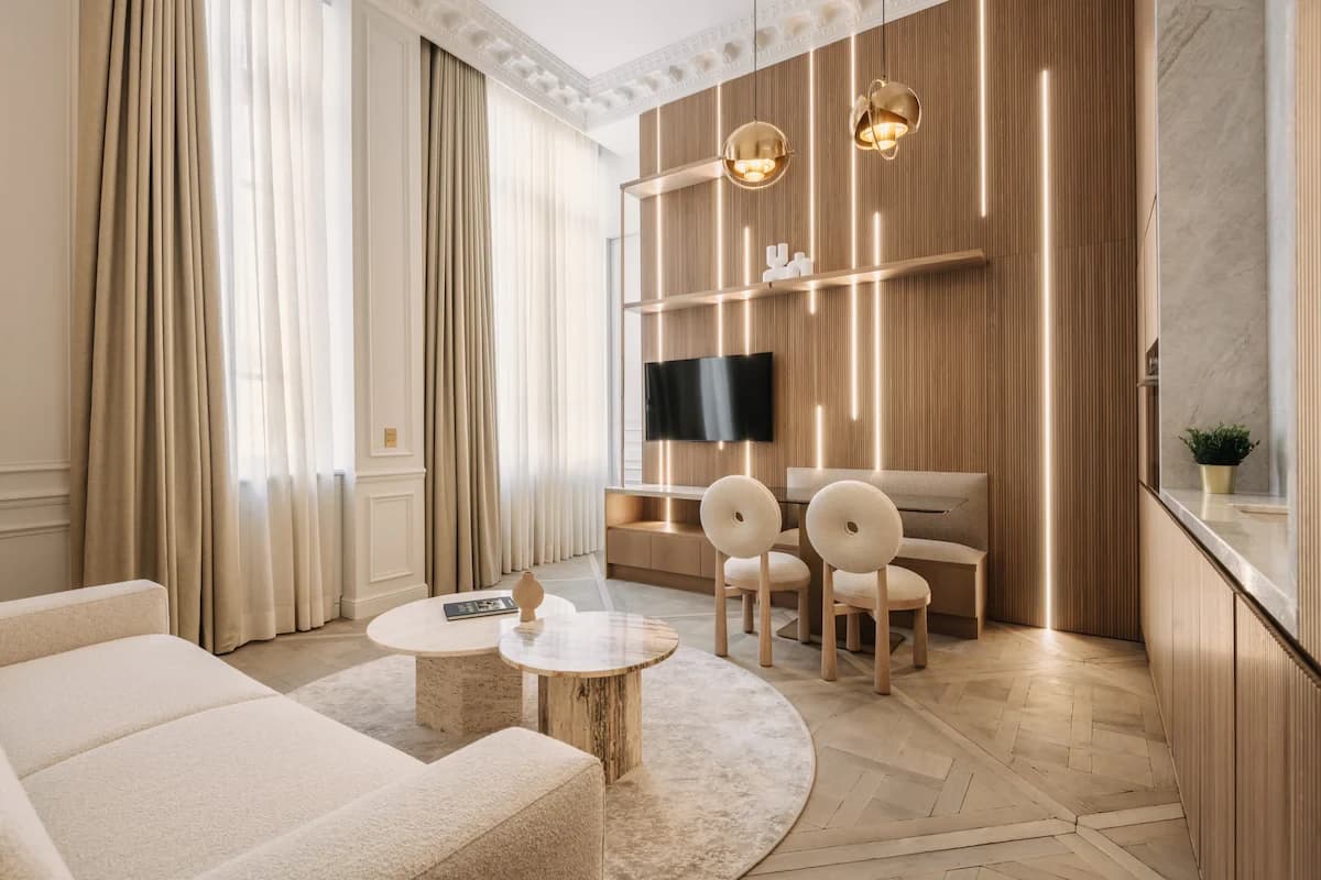 Wide Parisian living room with art wall, boucle sofa and travertine tables