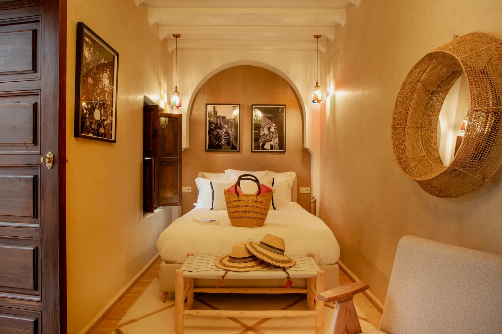 Arched bed nook framed by twin lanterns and black-and-white photography