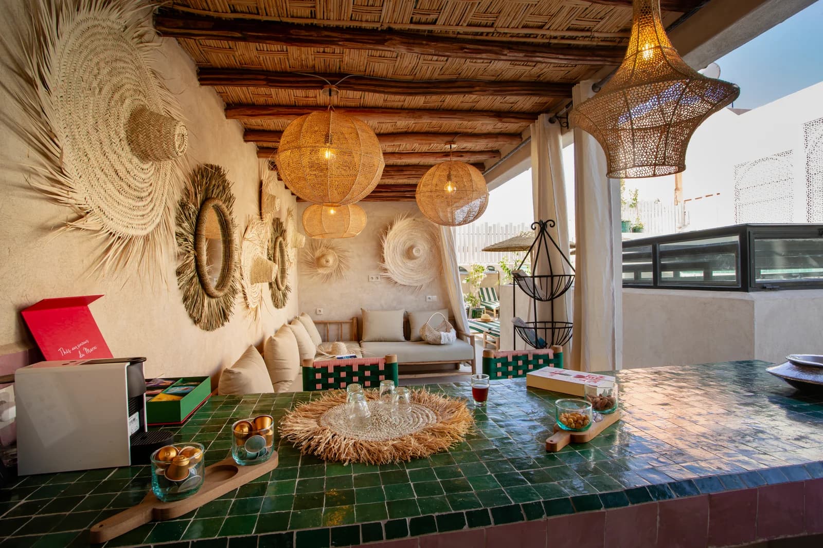 Green-tiled rooftop bar with rattan pendants and palm-frond mirrors