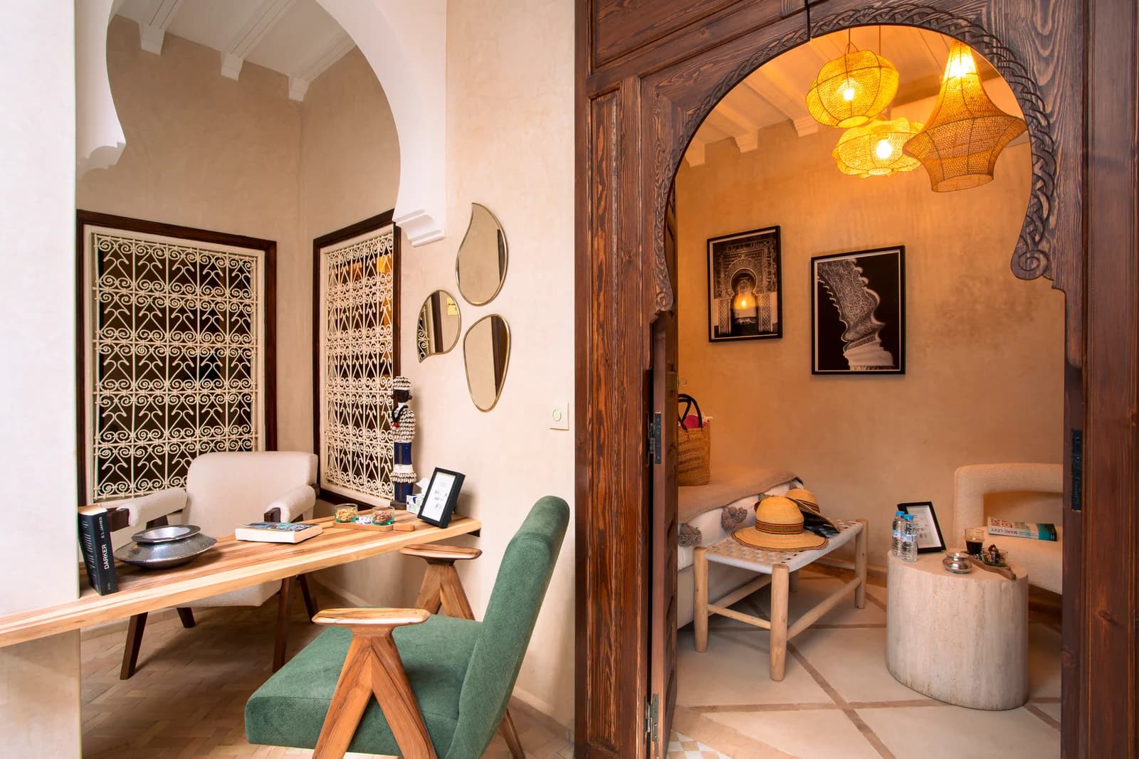 Reading nook with green chair, desk and ornate carved archway beyond