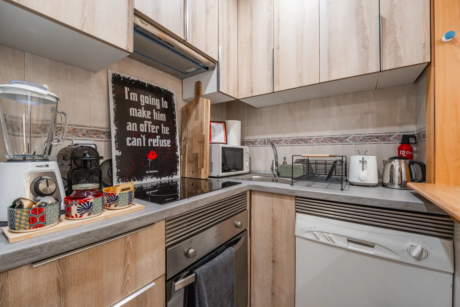 Kitchen corner with cooktop, oven and Godfather poster styling