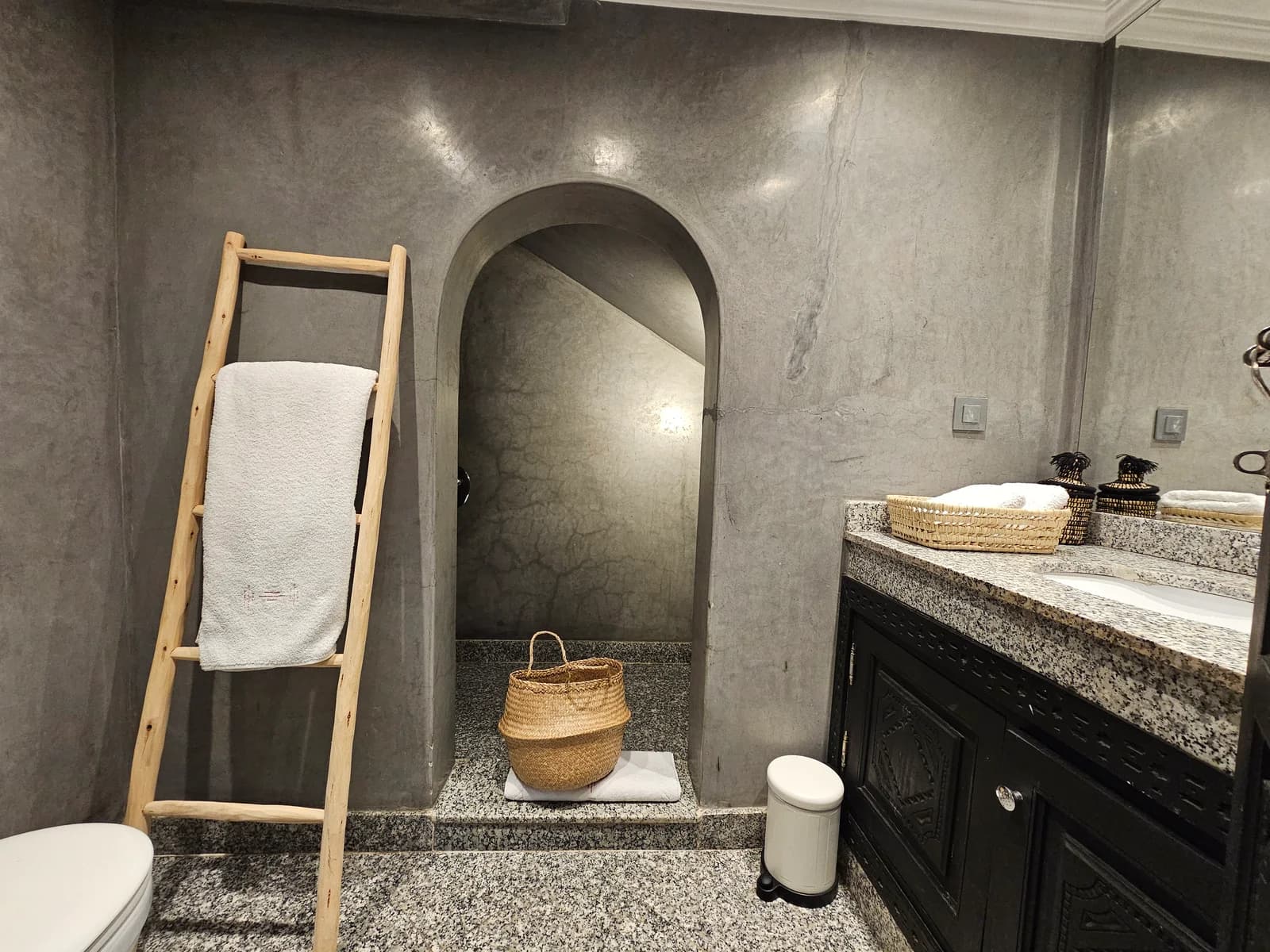 Tadelakt bathroom with arched shower entry and ladder towel rail