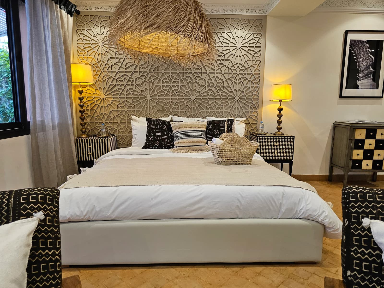 Master bedroom framed by intricately carved Moroccan headboard wall