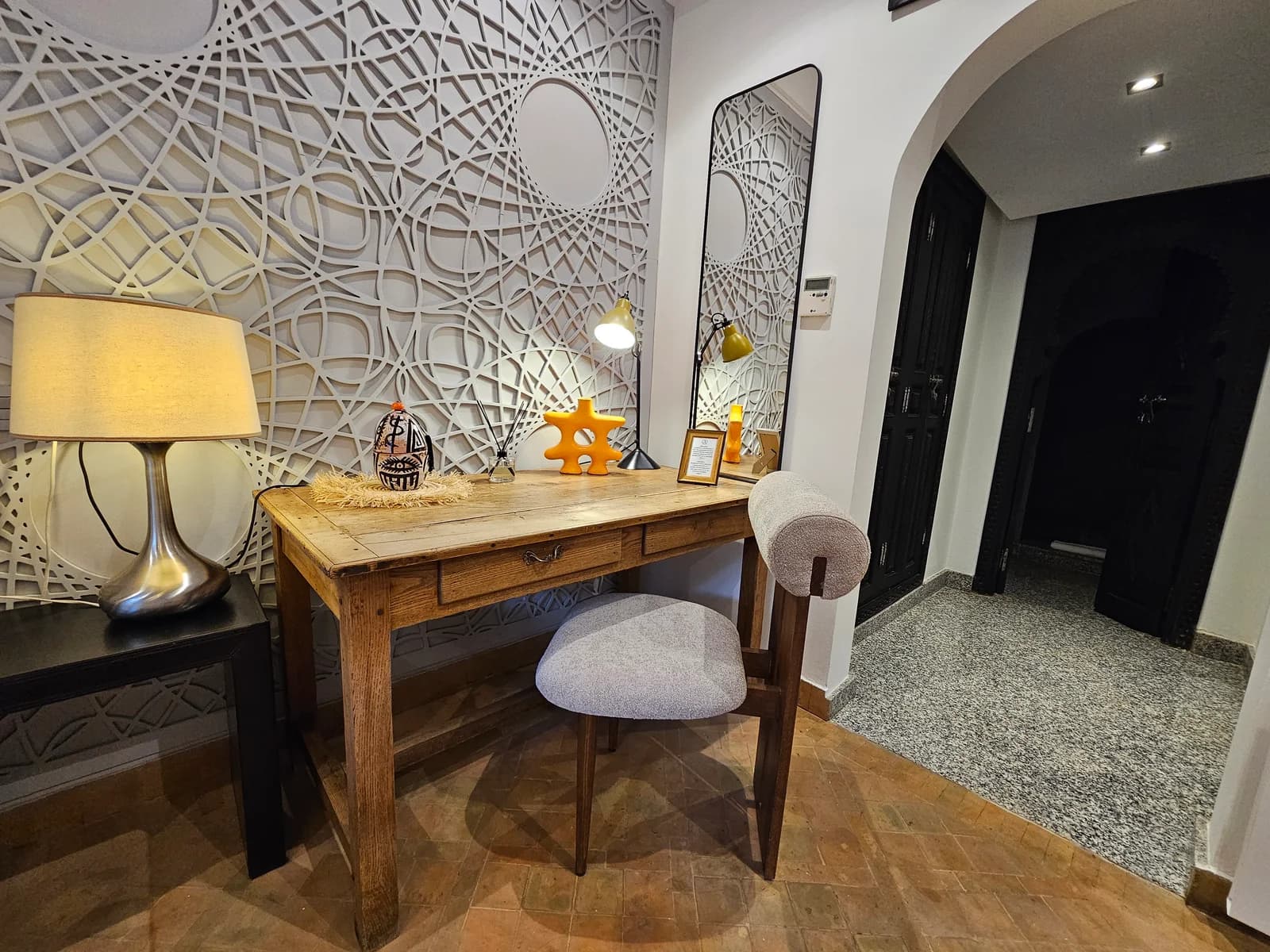 Vintage workspace desk against carved feature wall with table lamp