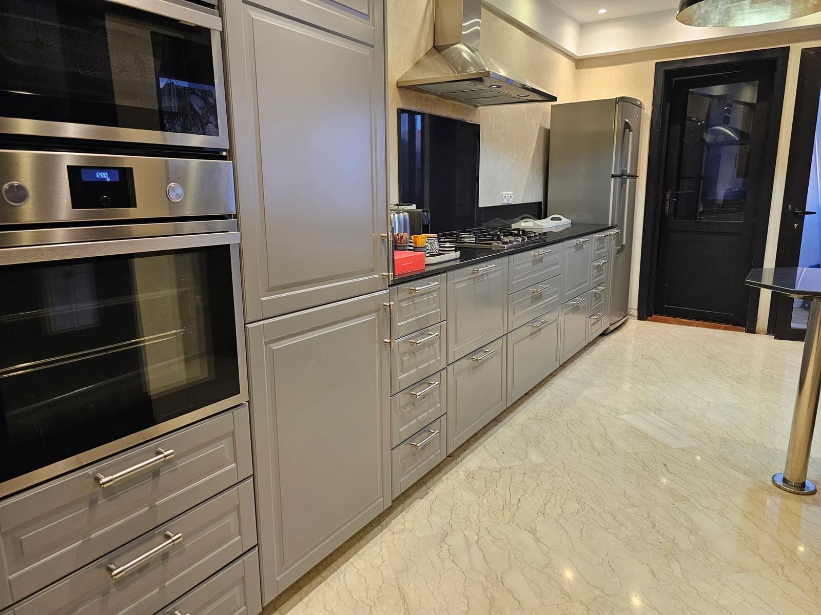 Detailed kitchen view of double oven, gas hob and grey shaker cabinets