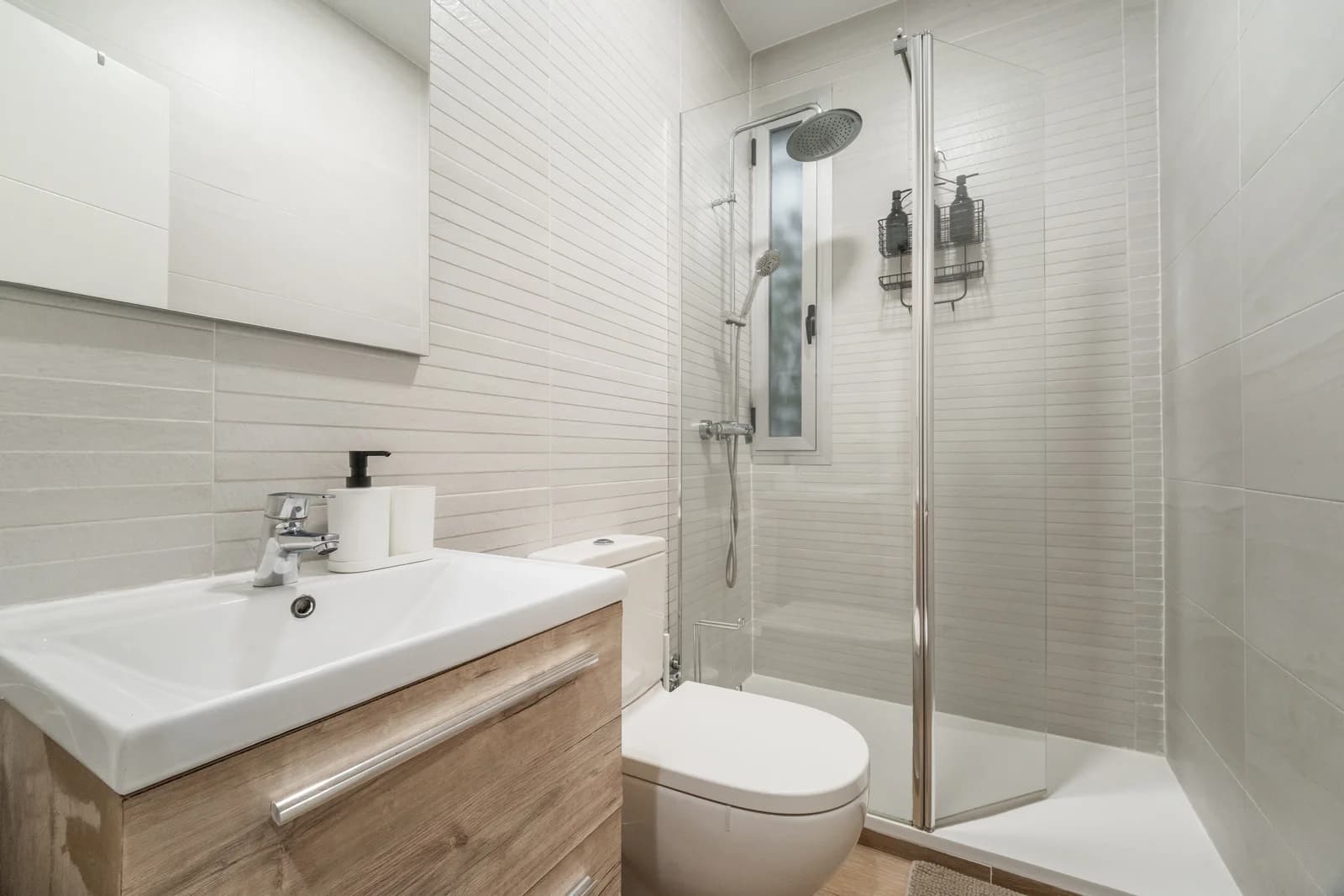Modern bathroom with walk-in glass shower and brick-pattern tile