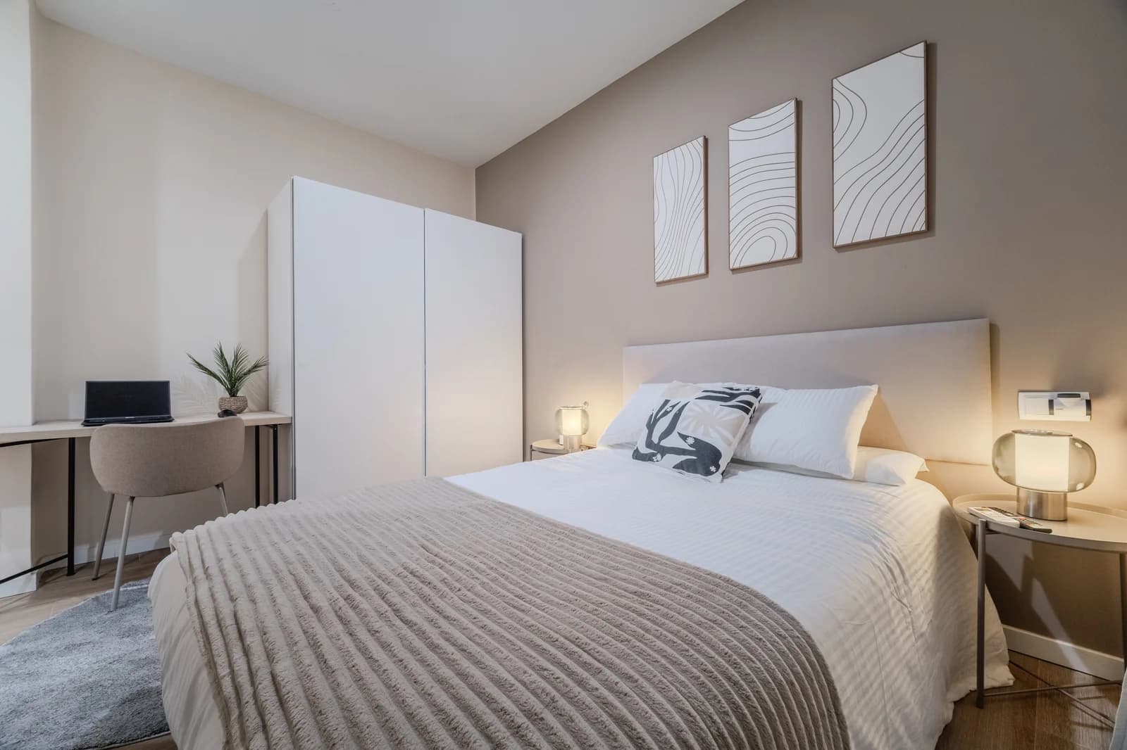 Bedroom with desk nook, taupe accent wall and abstract triptych art