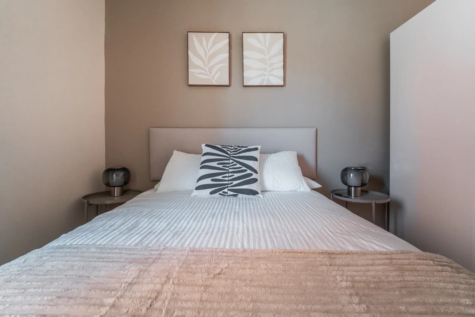Symmetrically styled bedroom with botanical diptych and twin lamps