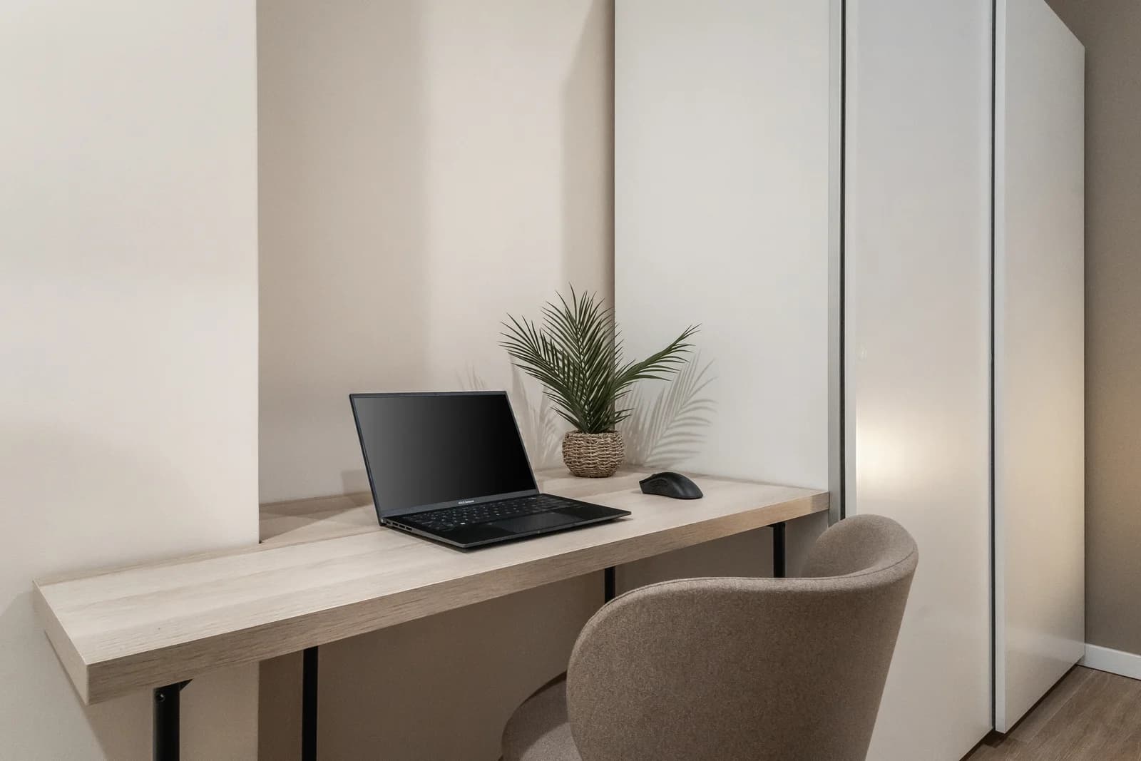 Editorial workspace nook with floating desk, plant and reading chair