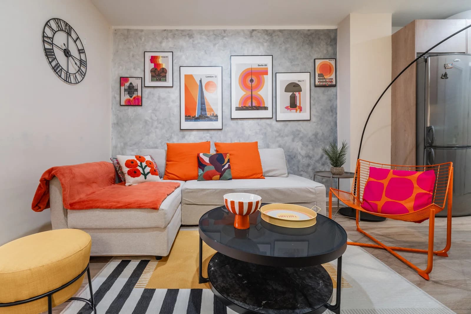 Cozy living view with orange wire chair, gallery prints and concrete wall