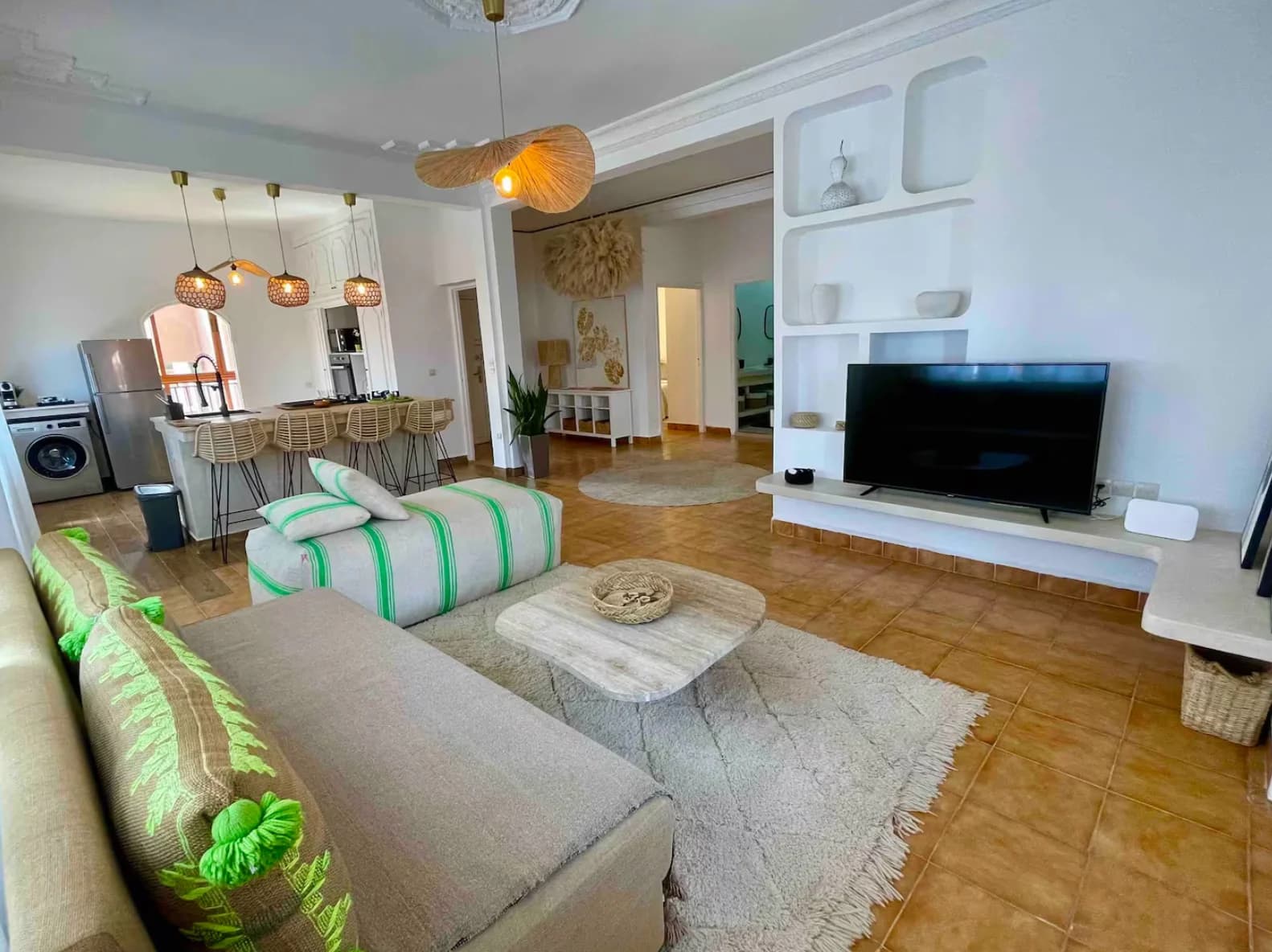 Wide bright living room with woven pendants opening onto kitchen