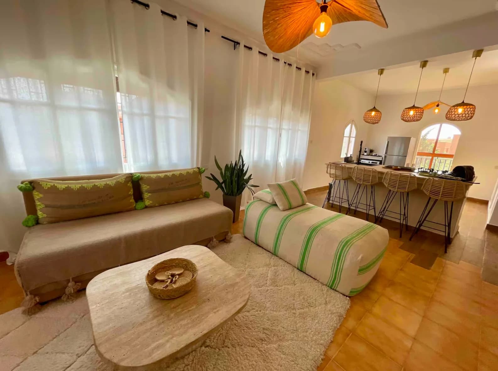 Linen sofa, travertine table, and rattan pendants beneath arched openings