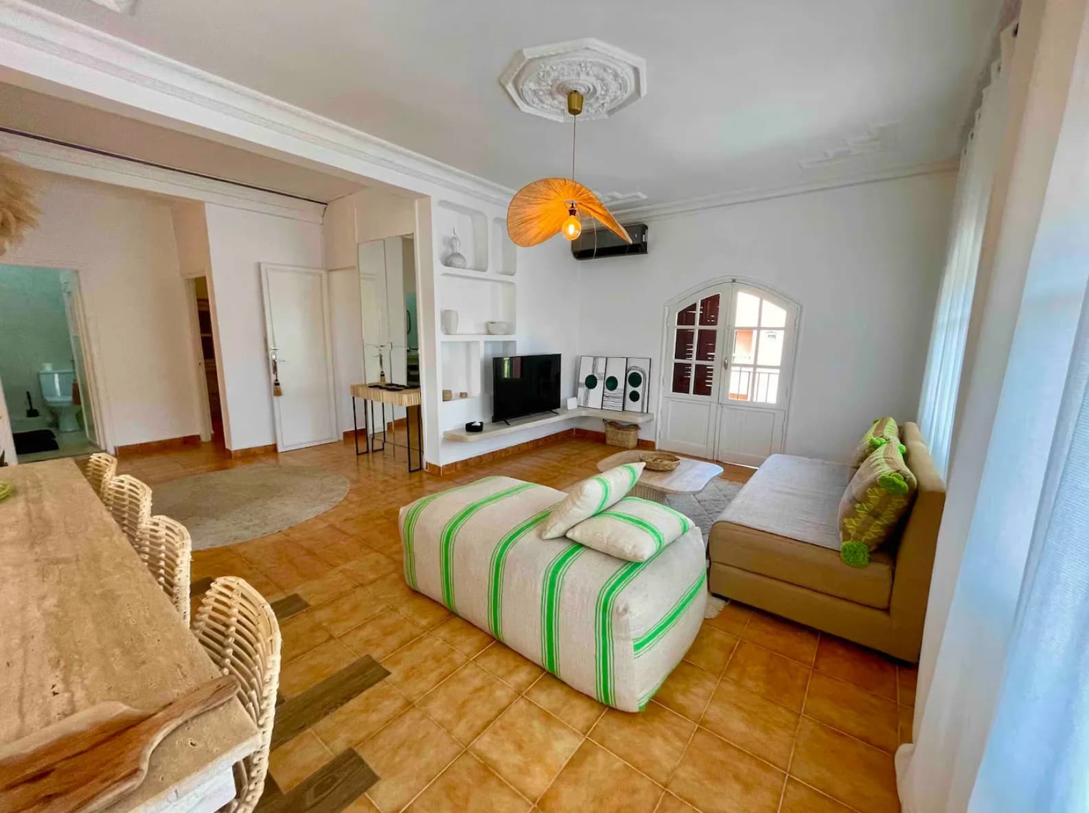 Open living-dining area with arched windows and woven dome lamp