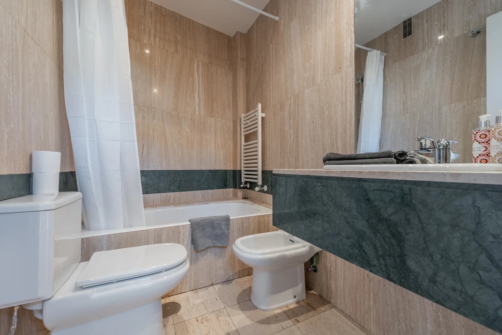 Travertine bathroom with green marble band and tub-shower combo