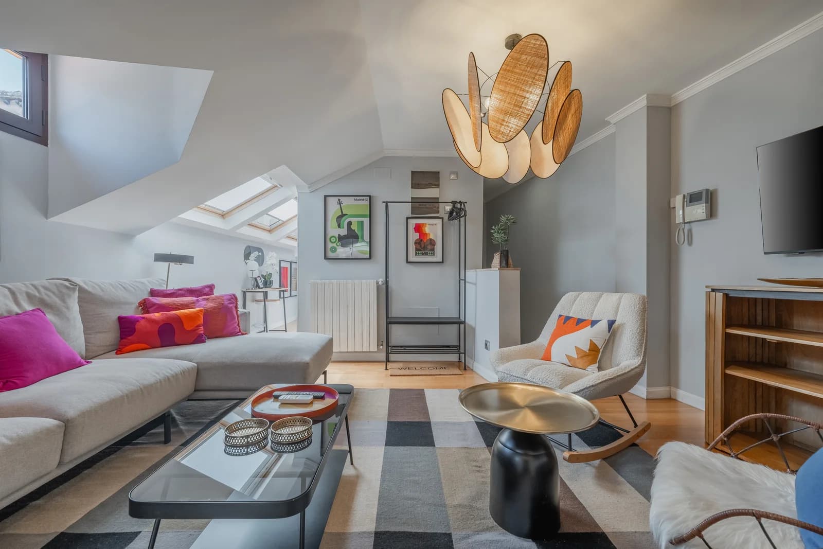 Attic living room with sculptural rattan pendant and gallery wall