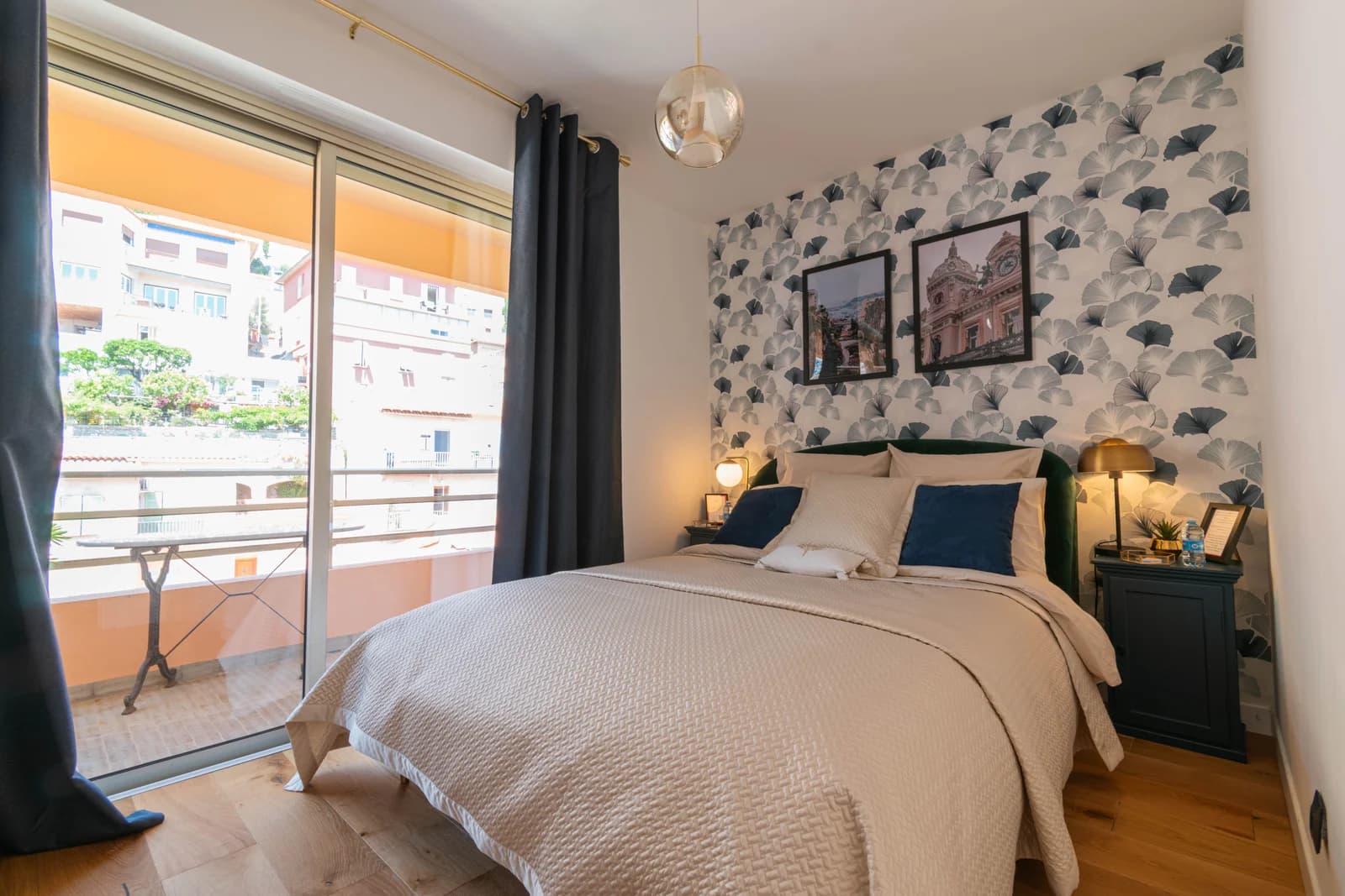 Second bedroom with botanical wallpaper opening to sunny balcony