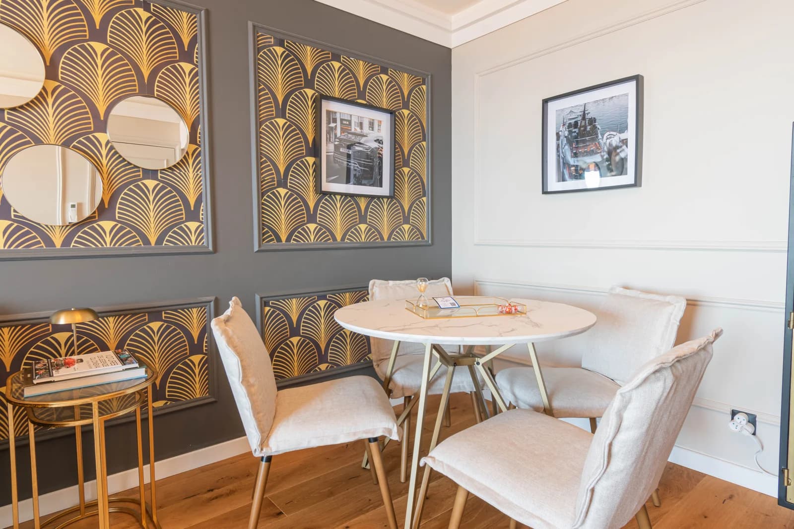 Round marble dining table set against deco gold-fan wallpaper