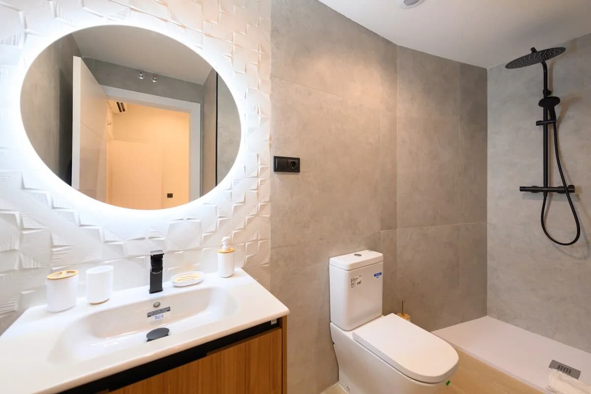 Backlit round mirror, 3D textured wall and walk-in rain shower