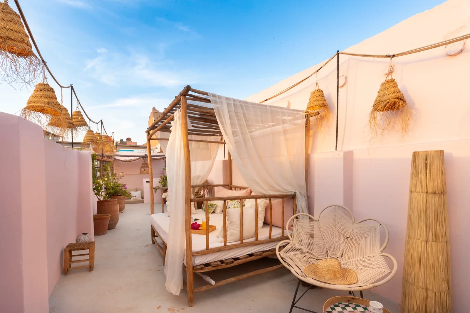 Rooftop terrace with canopied daybed and string-lit pergola at dusk