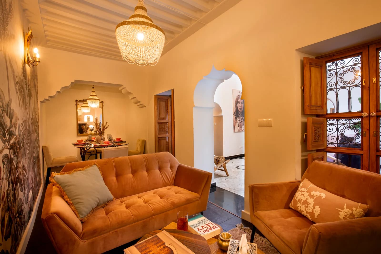 Twin tan velvet sofas in archway lounge with dining alcove beyond