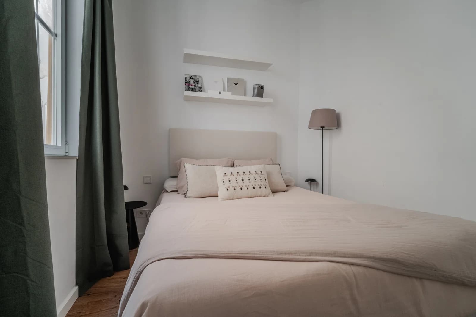 Compact bedroom with green velvet curtains and minimal styling