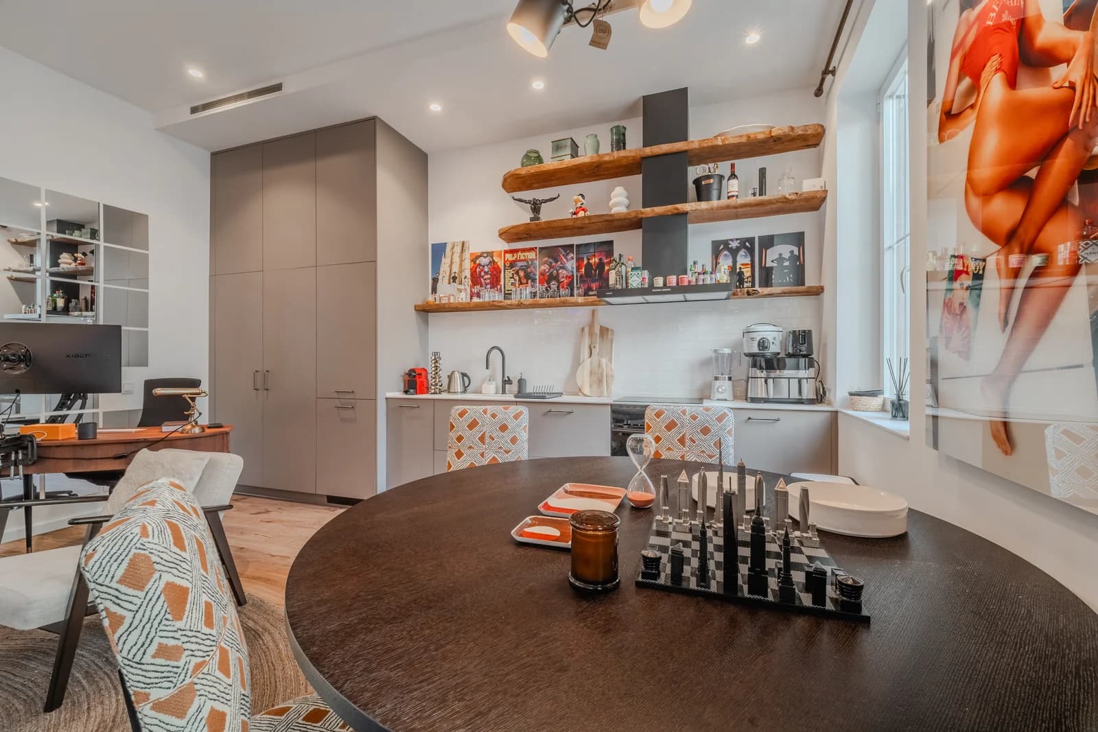 Espresso-walnut dining table beside grey kitchen with pop-art accent
