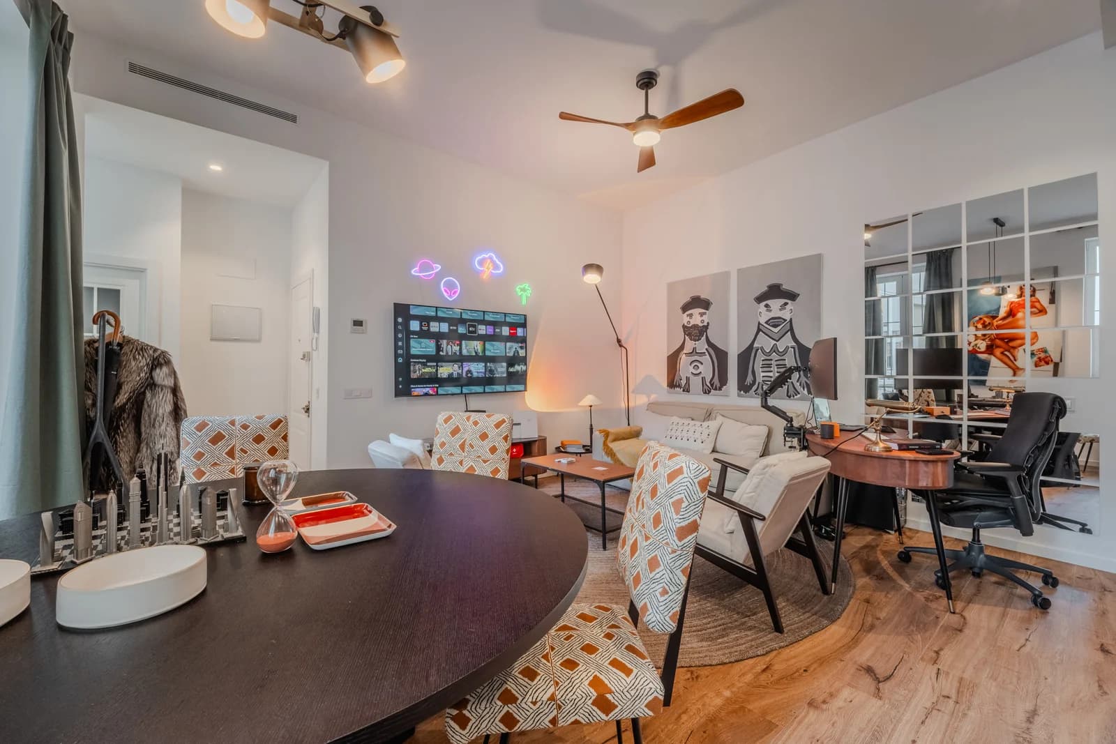 Living-dining area with neon planets, oval table and ceiling fan