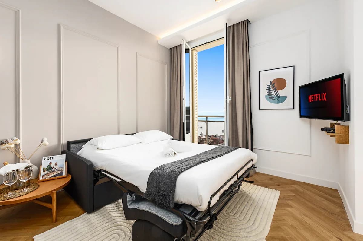 Sofa-bed bedroom with French doors opening to balcony view