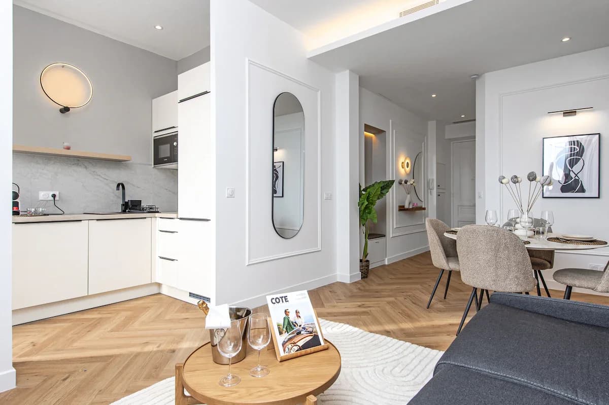 Compact white kitchen with marble splashback and ring sconce