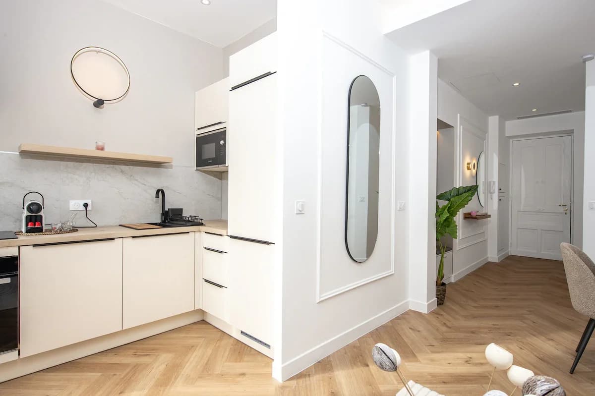 Kitchen and entry with elliptical mirror and herringbone parquet