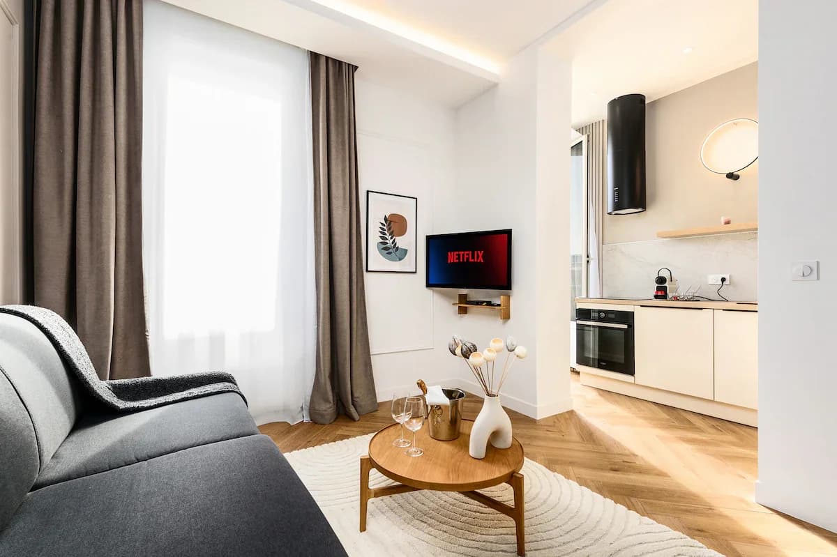 Living area with floor-to-ceiling curtains and modern wall sconce