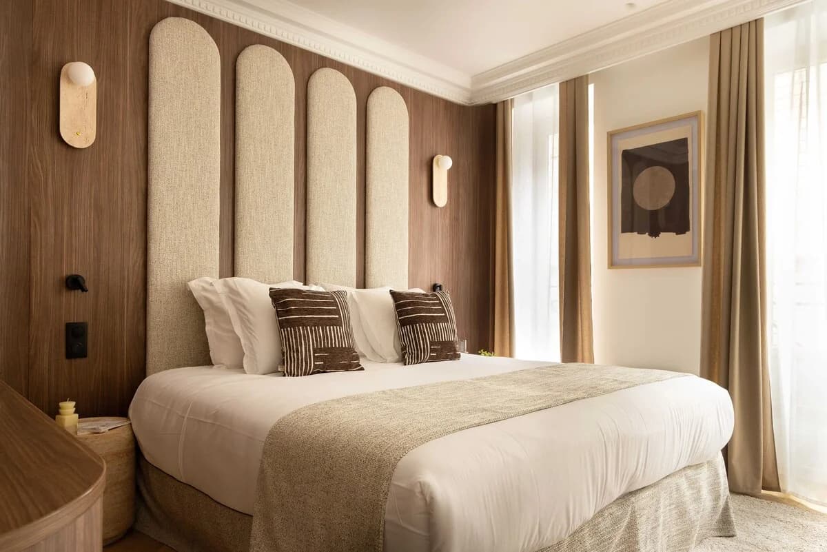 Master bedroom with arched bouclé headboard panels and walnut walls