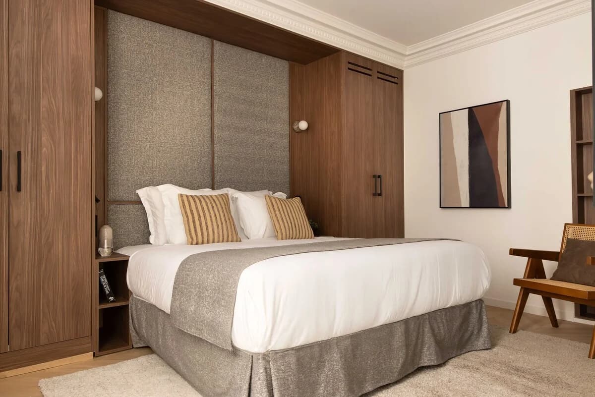 Second bedroom with built-in walnut wardrobes flanking the bed