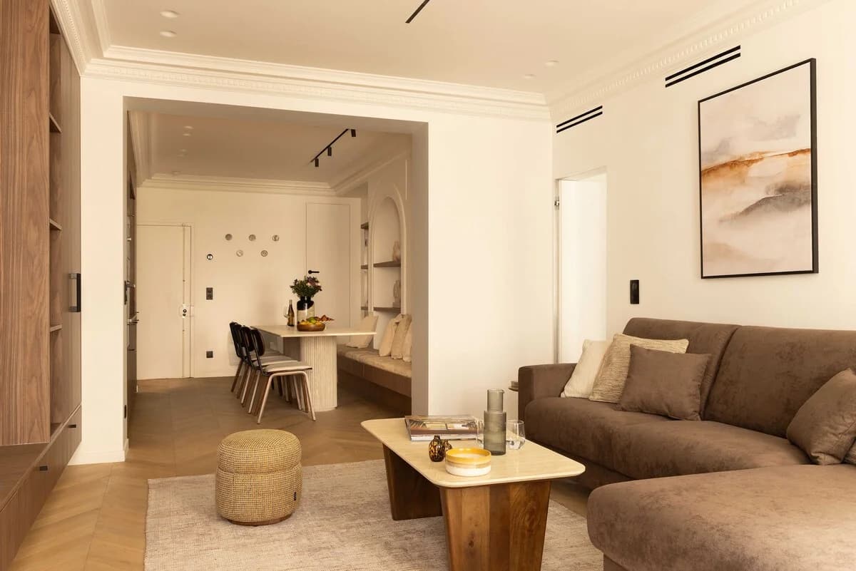 Open living room with brown velvet sofa looking through to dining banquette