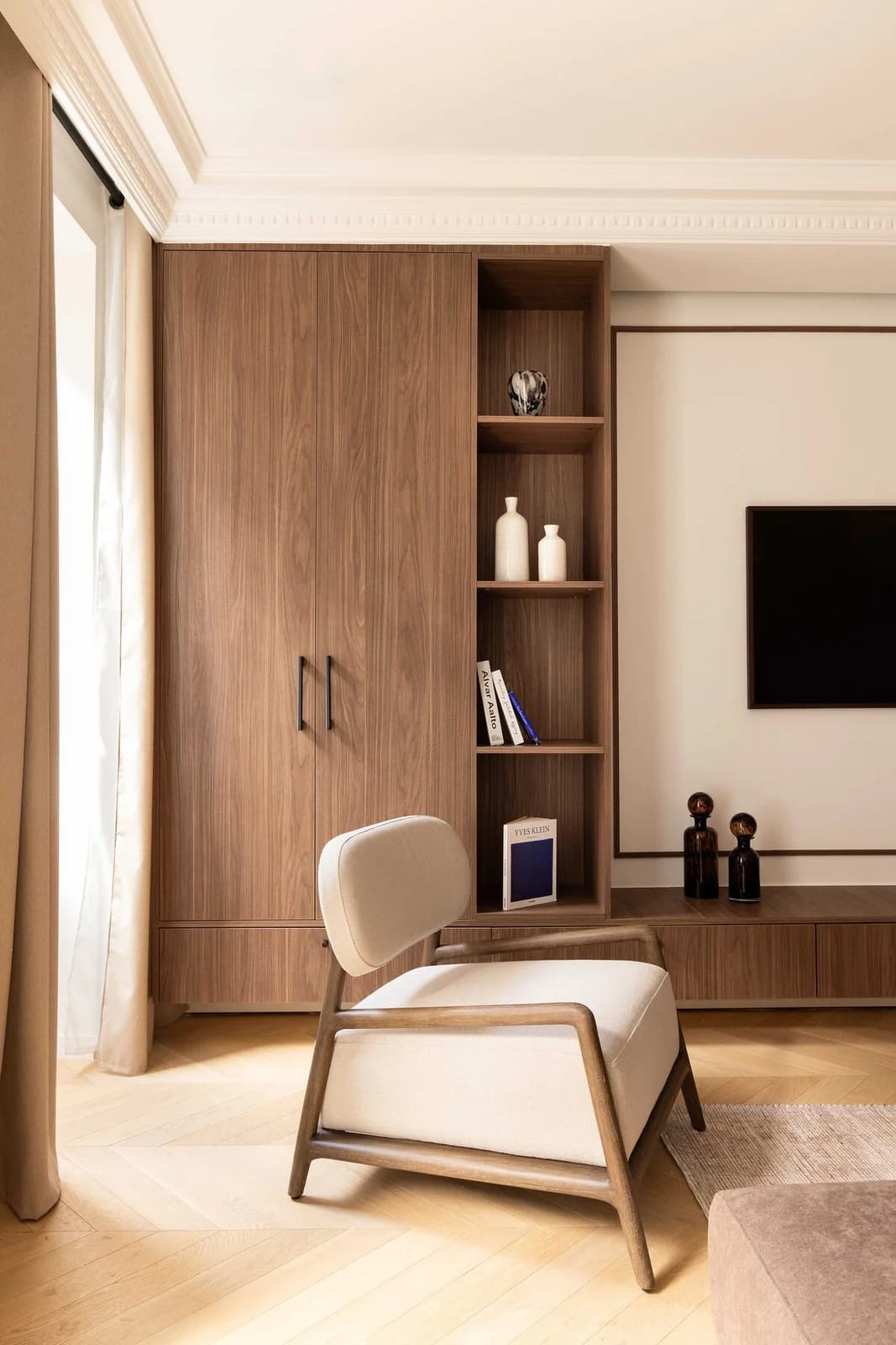 Walnut joinery with sculptural armchair and integrated TV niche