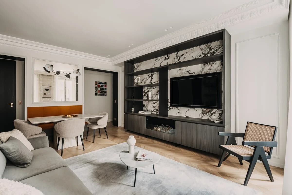 Living room with marble and joinery TV wall, Pierre Jeanneret-style chair