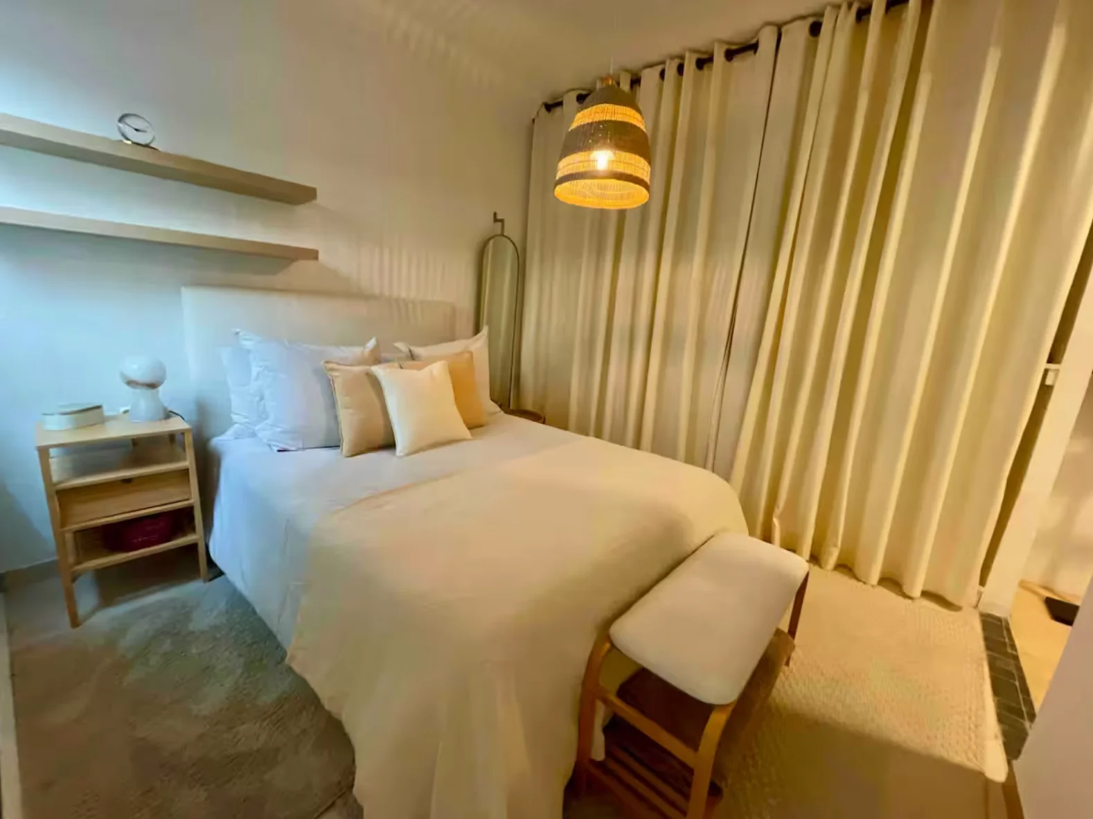 Curtained bedroom retreat with woven pendant and shelf vignette