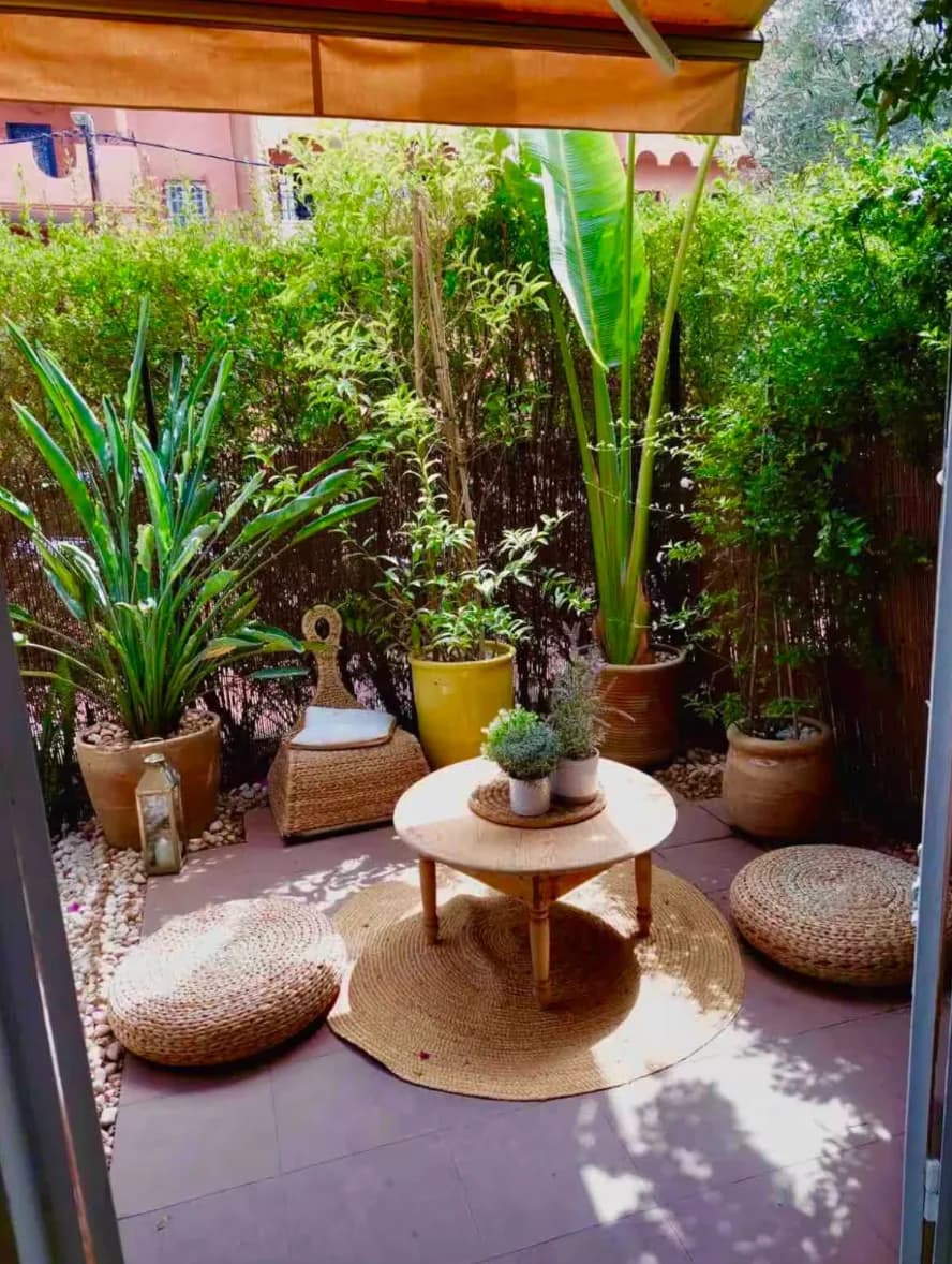 Private bamboo-screened patio with pouf seating and round wood table