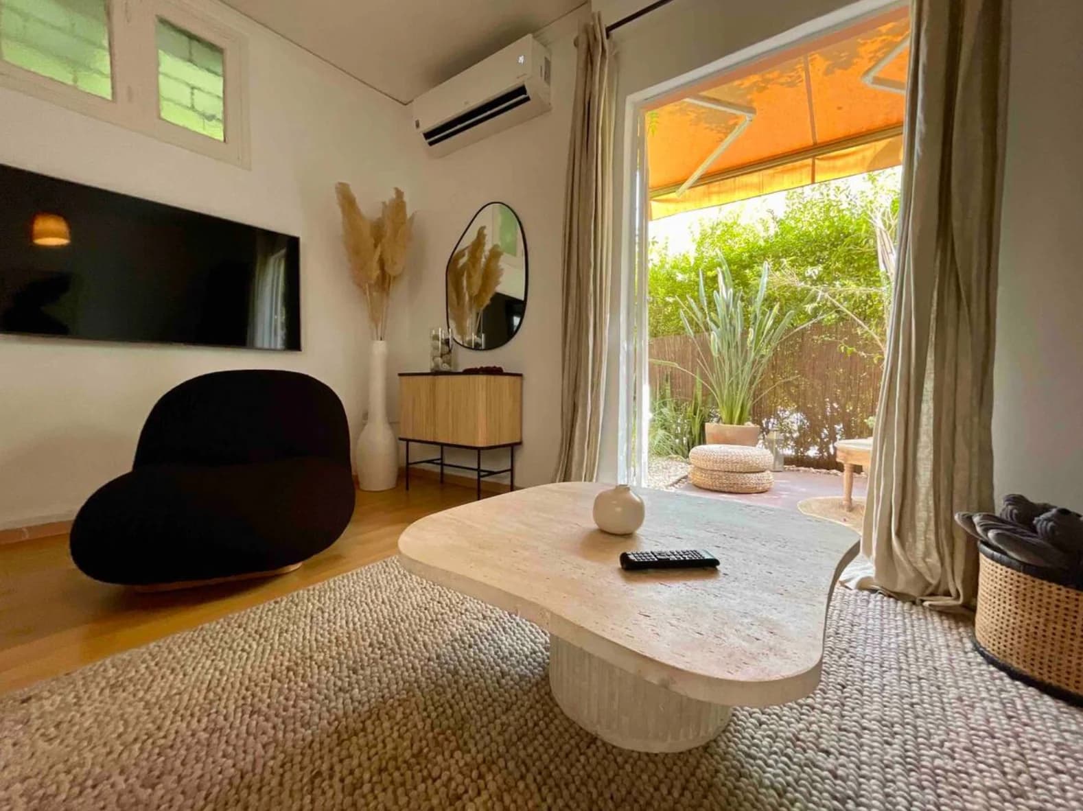 Living room opening through floor-to-ceiling doors to lush garden patio