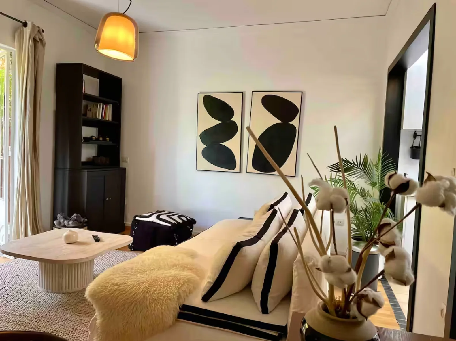 Cosy living corner with black bookcase and abstract diptych