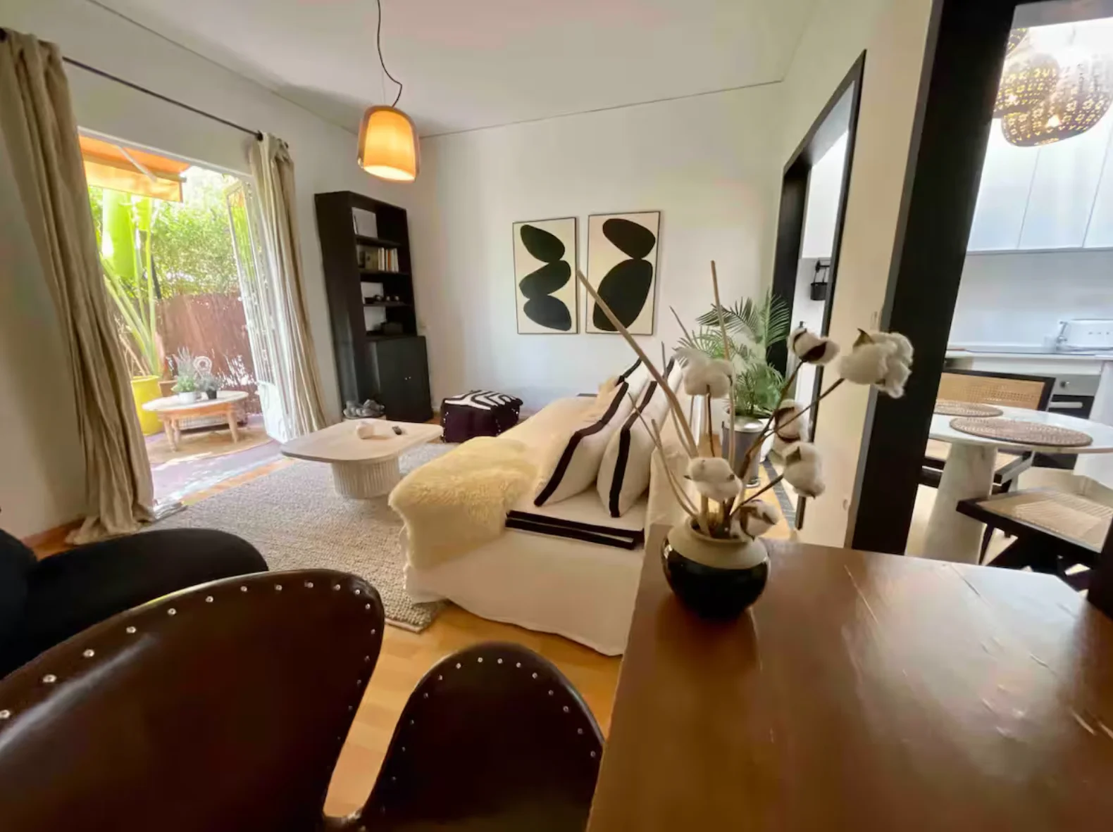 Lounge framed by leather chair with cotton stems and patio doors