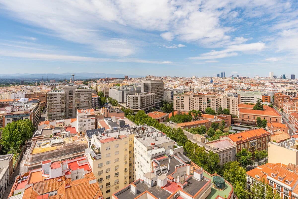 High-floor view across central Madrid rooftops toward distant skyline