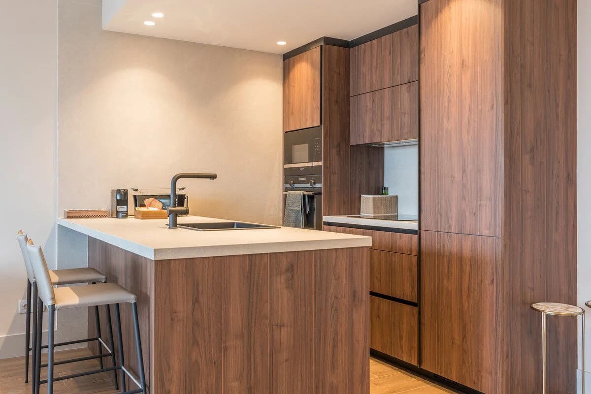 Walnut kitchen island with stone counter and integrated appliances