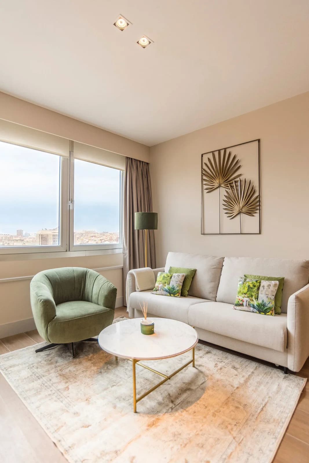 Sage and cream lounge with golden palm wall art and marble table