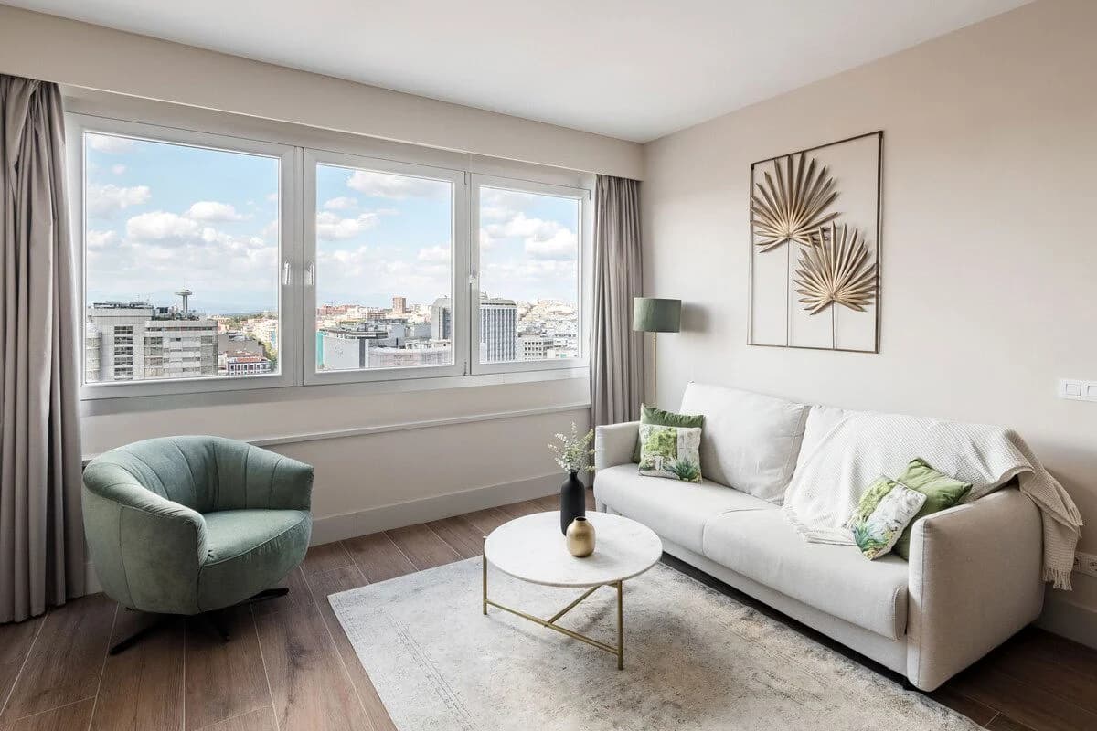 Light-filled corner with velvet armchair beside the city skyline