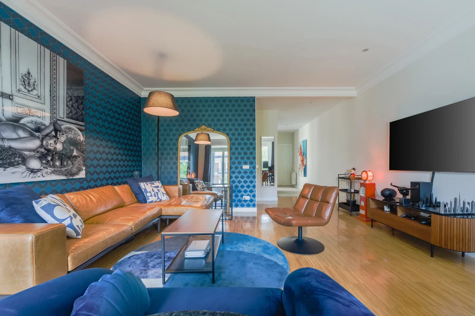 Bold blue patterned lounge with leather sectional and mirrored archway